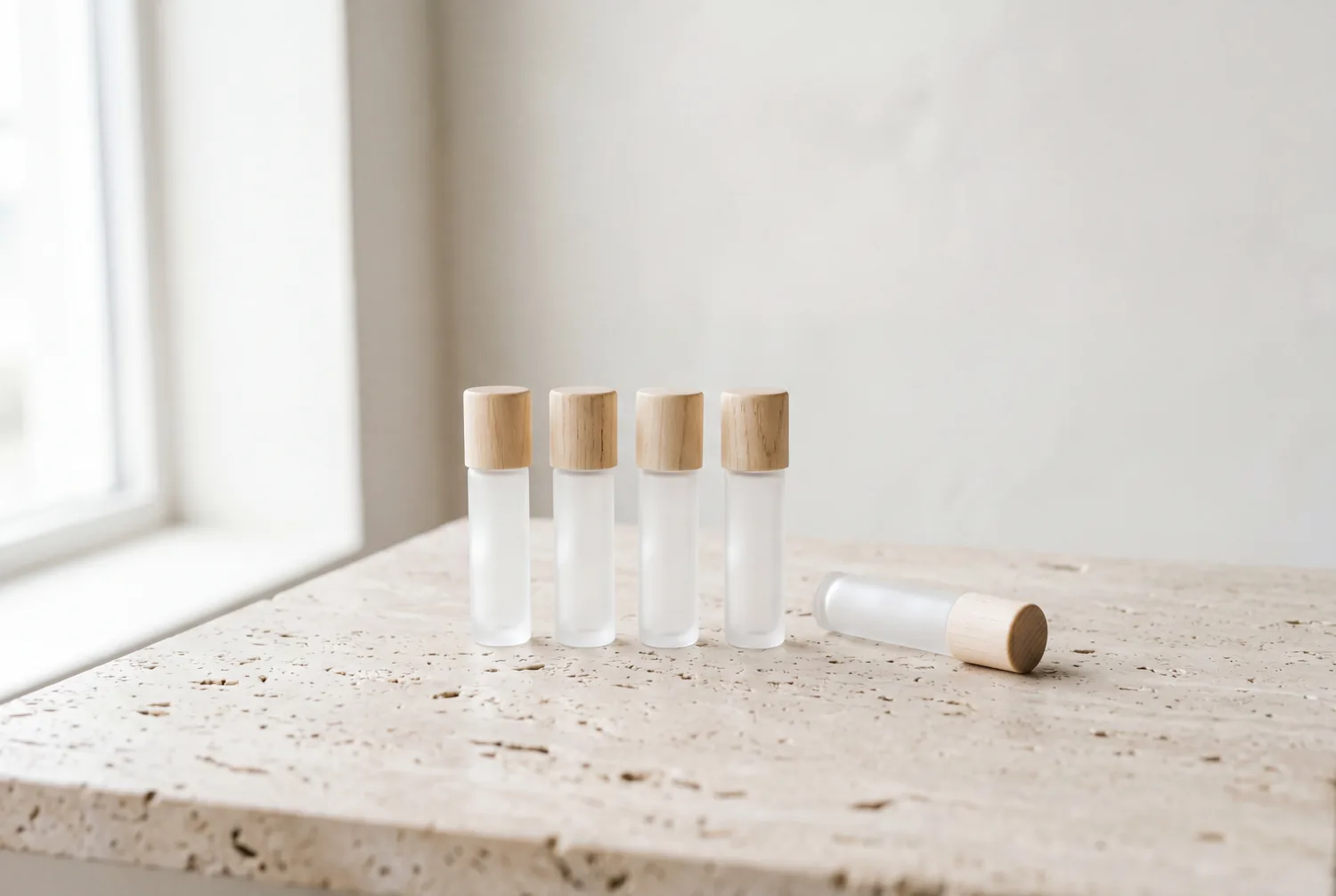 Five frosted discovery vials lined up on a travertine slab